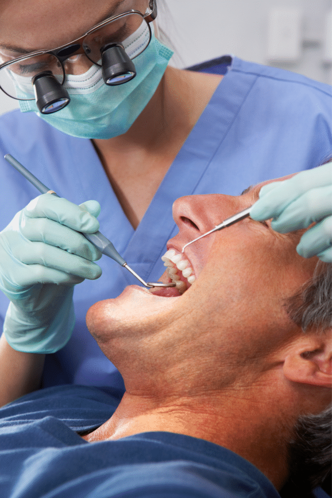 Dentista com lupas de aumento examinando um paciente