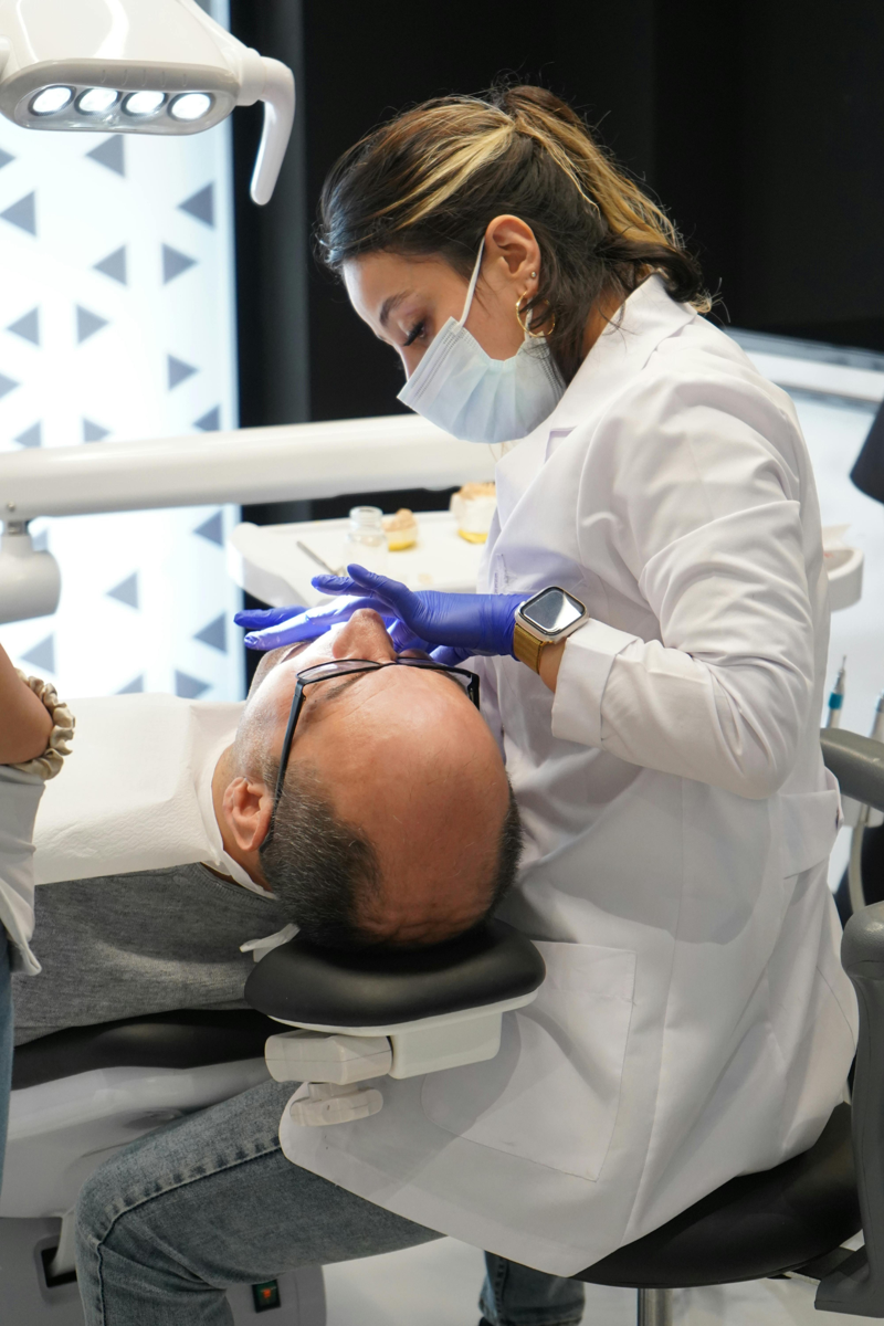 Dentista atendendo um paciente na cadeira odontológica