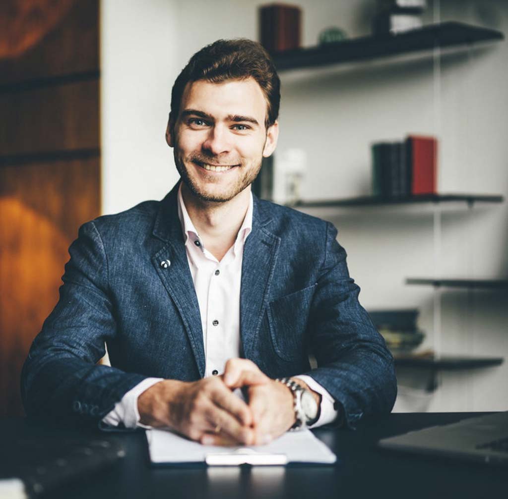 Profissional sorridente sentado à mesa do escritório