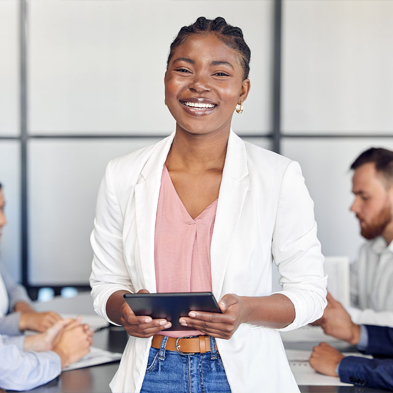 Empreendedora sorrindo com um tablet nas mãos, no escritório