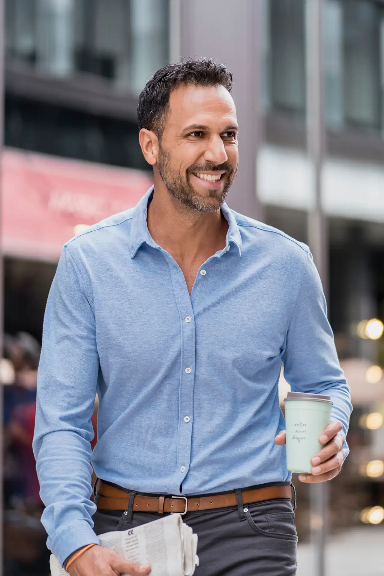 Profissional sorridente segurando um copo de café